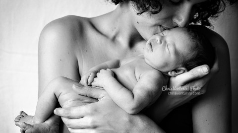 Primer plano de una madre besando a su bebé en brazos